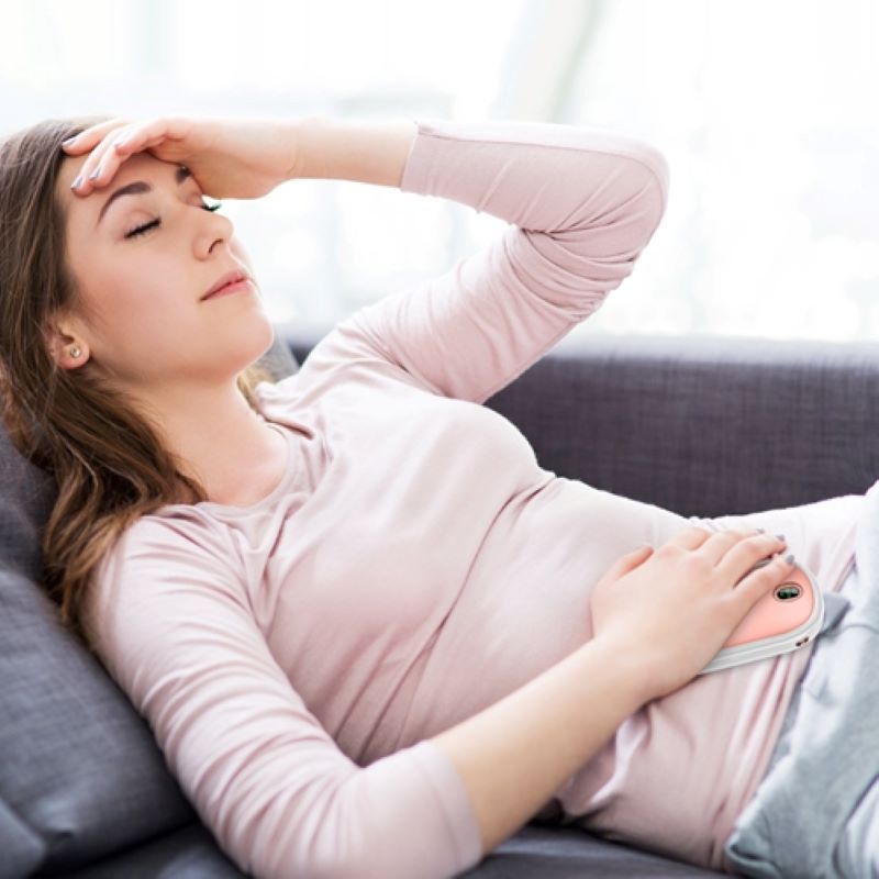 person using a portable hand warmer for abdominal comfort and warmth