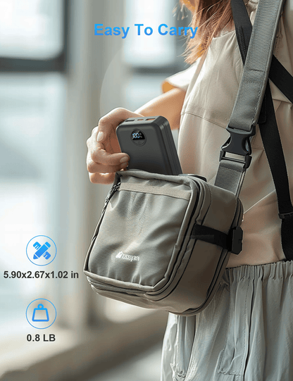 compact portable power bank being placed into a small shoulder bag for easy carrying